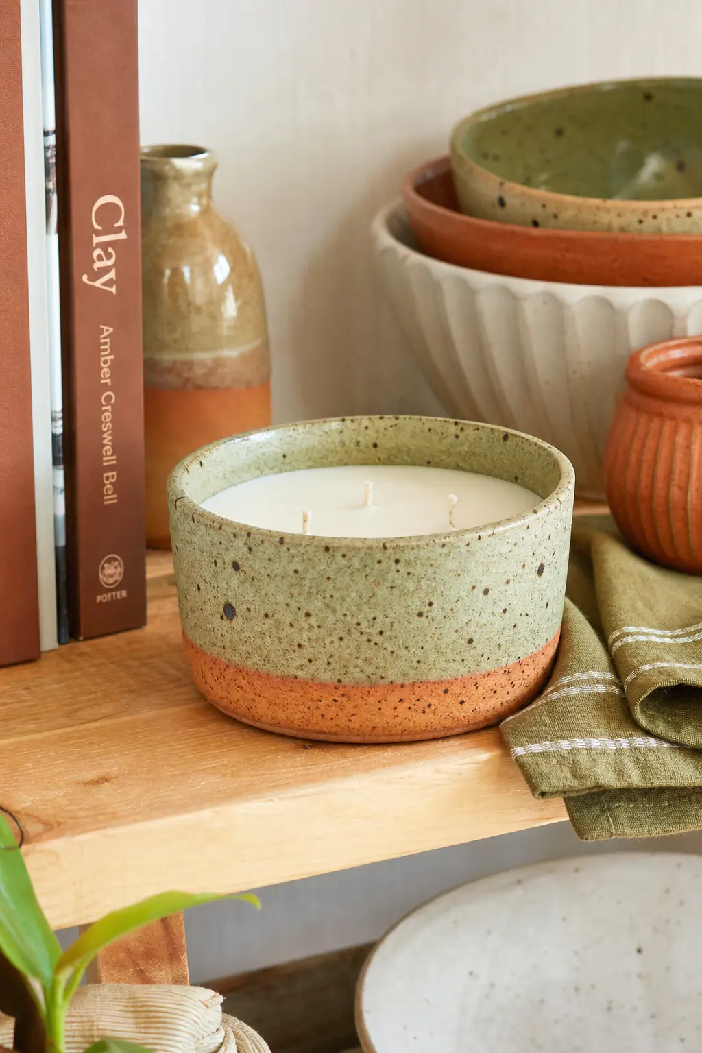 Speckled Stoneware Bowl Candle — A small handmade-looking stoneware bowl, the kind with visible speckling in the glaze, takes a sage and fig fragrance well and