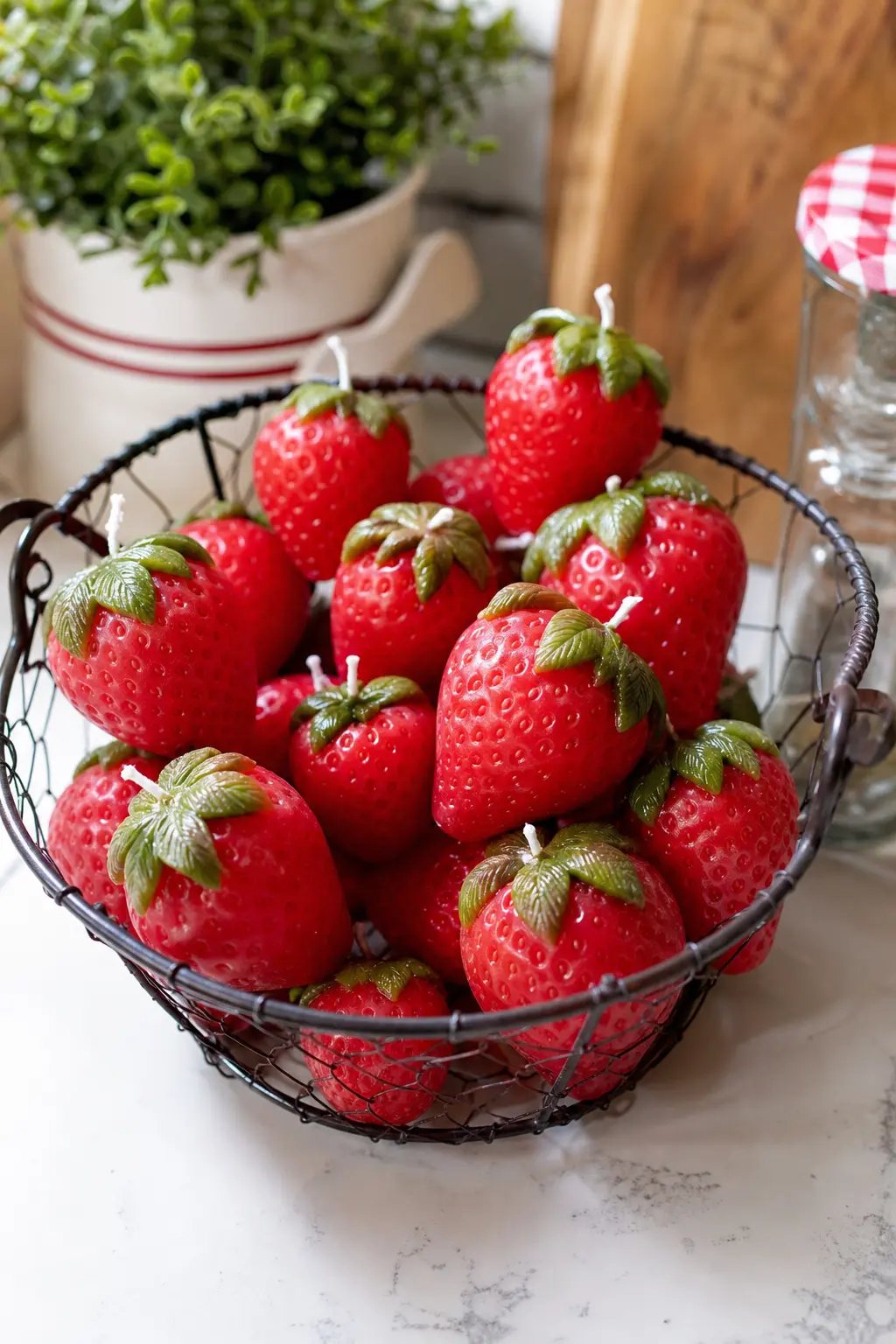 Strawberry Cluster Candle — A cluster of strawberry candles in deep red with a green wax calyx detail sells itself at a market table without a single word of