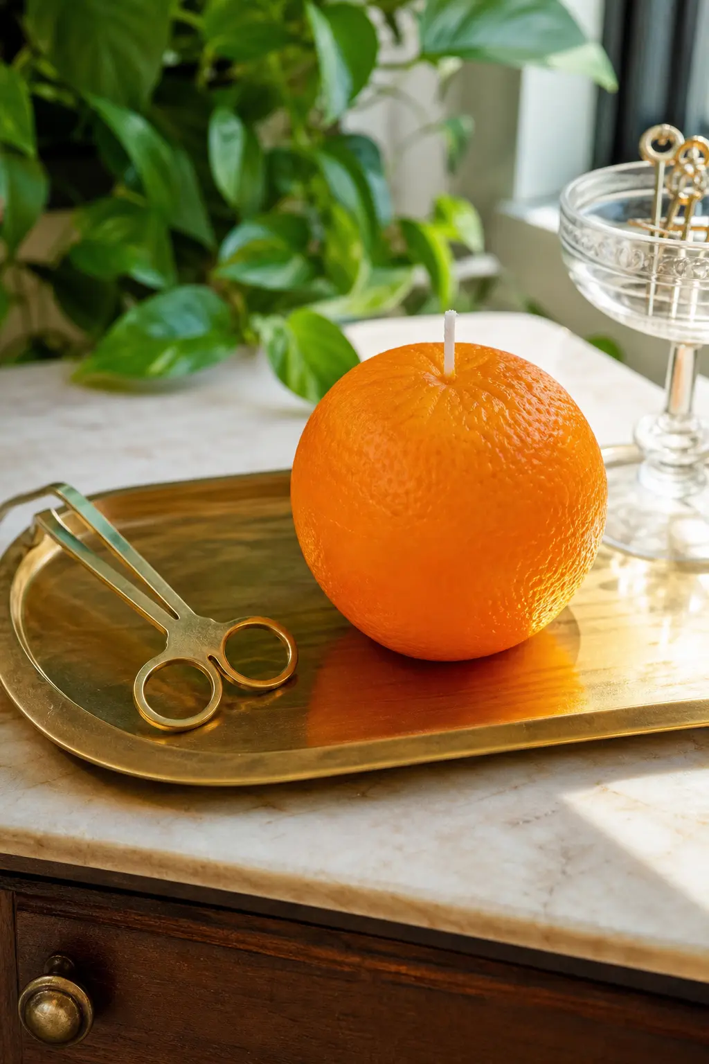 Whole Orange Candle with Peel Texture — A whole orange candle, textured to look freshly peeled, sits bright against brass on a bar tray, with blood orange and