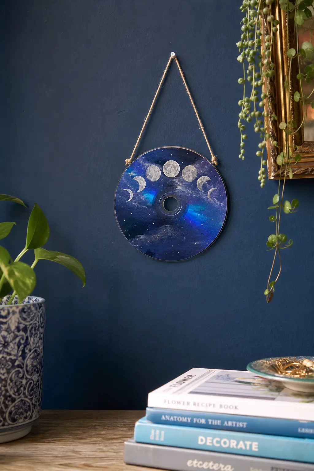 Moon Phase Arc — A curved row of moon phases from crescent to full, painted in silver white against a deep indigo base, turns the disc into a tiny lunar