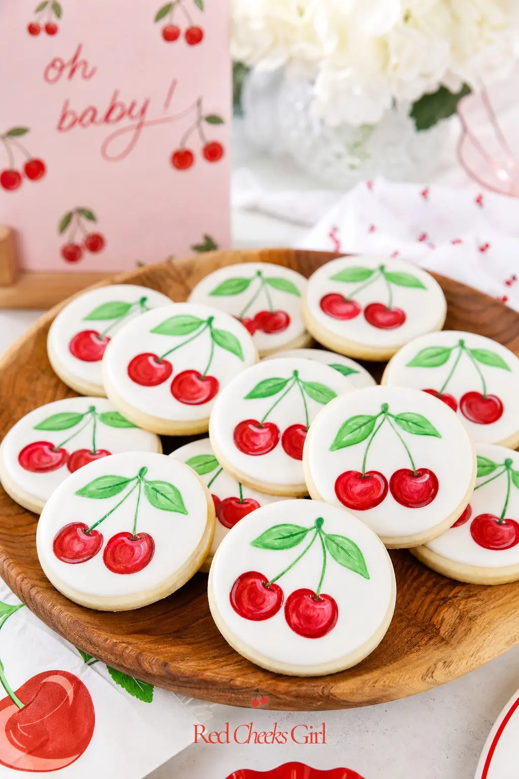 Hand-Painted Cherry Sugar Cookies — Decorated cookies shaped like cherries or featuring cute baby-themed designs bring an extra layer of creativity to the
