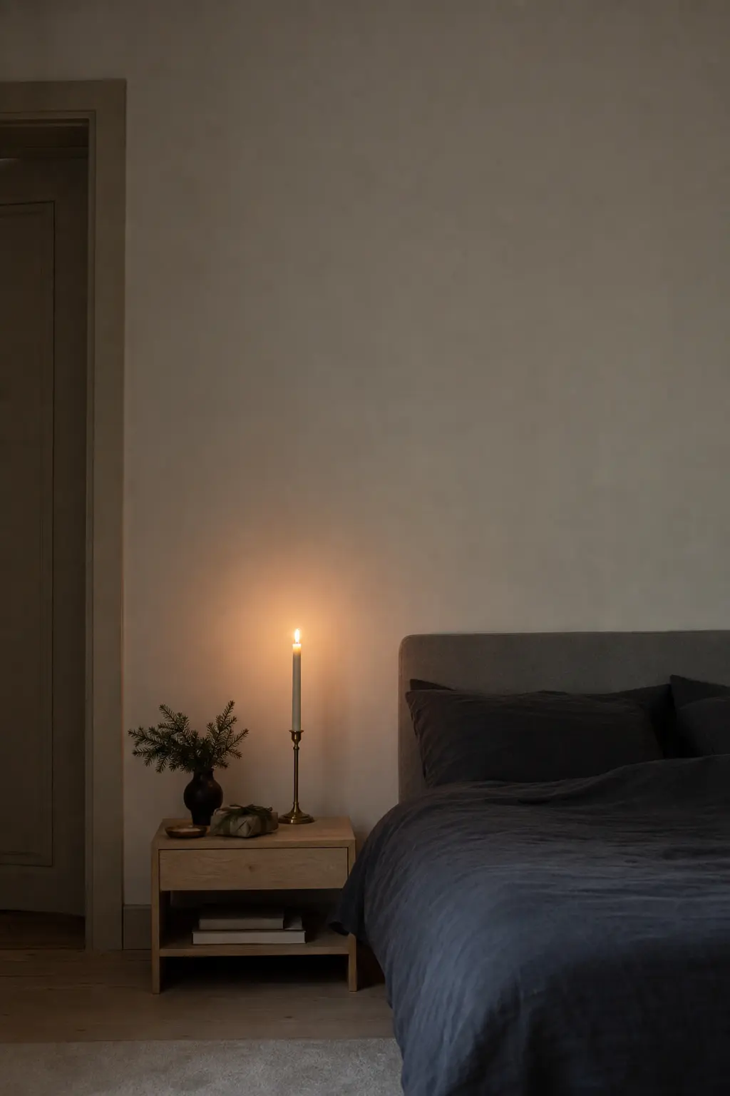 A Single Tall Taper on a Bedside Table