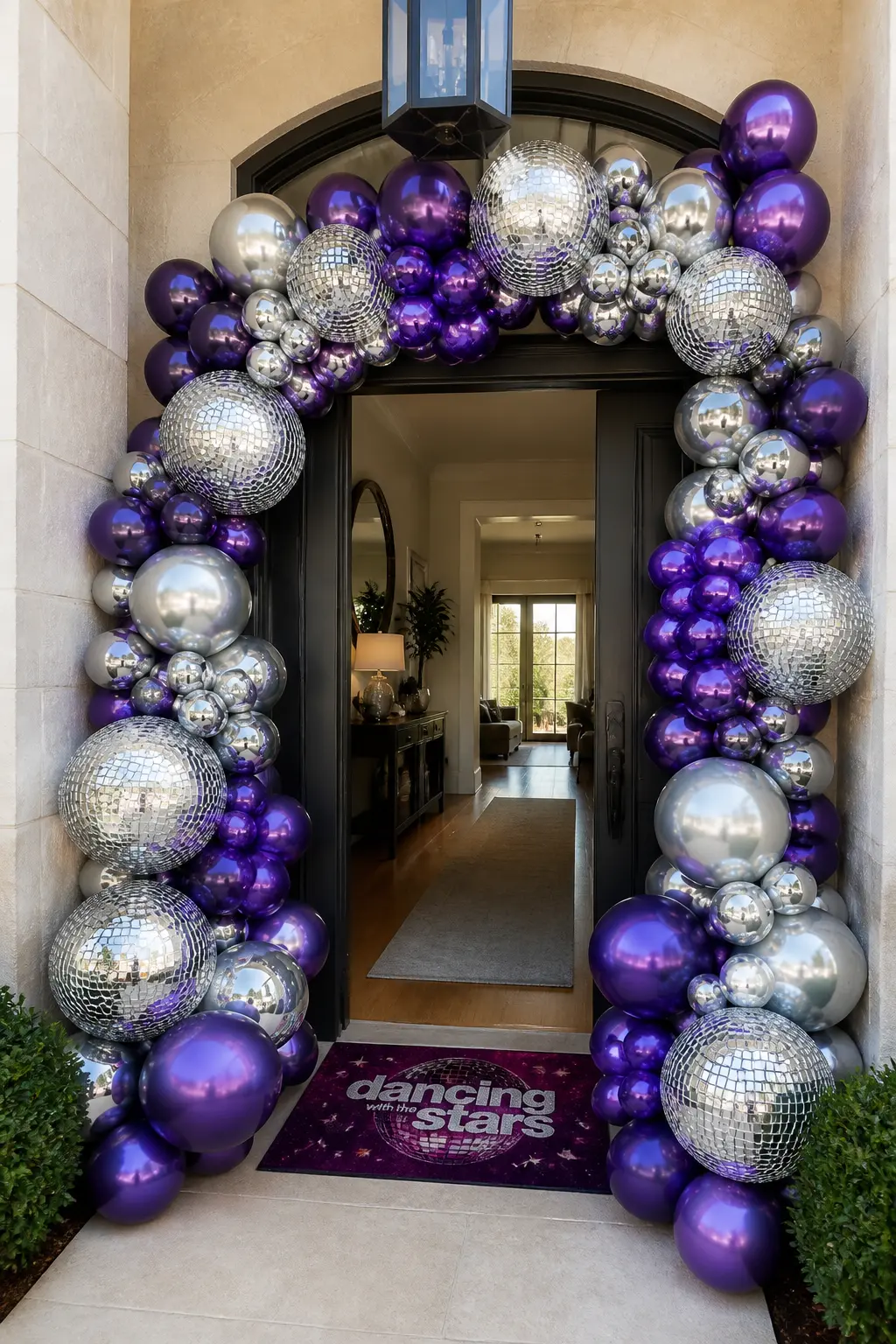 Mirror Ball Balloon Arch at the Front Door — Silver chrome balloons and deep violet latex balloons, alternating in clusters, frame a doorway from floor to