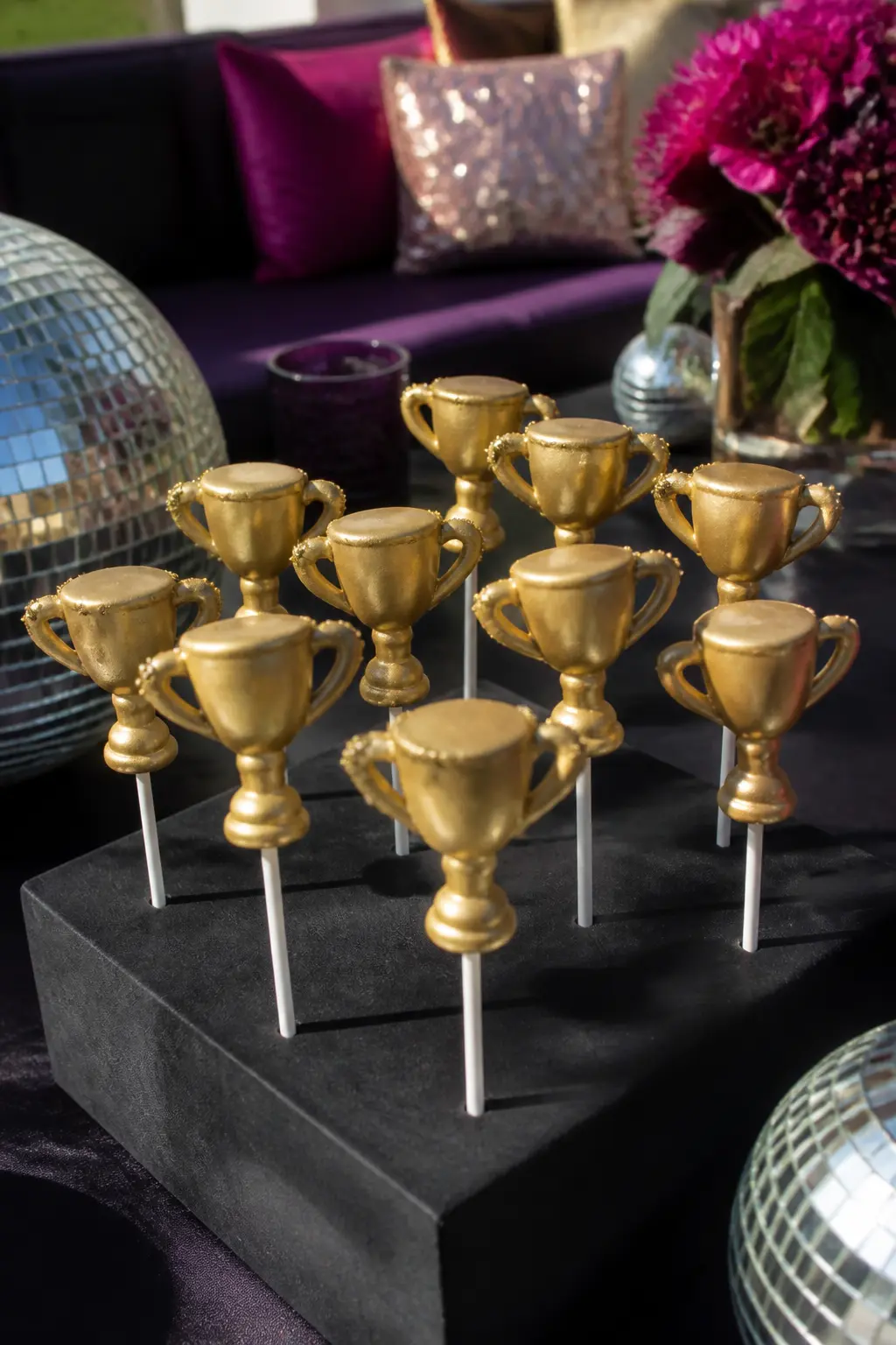 Trophy-Shaped Cake Pops — Cake pops dipped in gold candy coating and pressed into a styrofoam block covered in black paper look like a row of tiny trophies