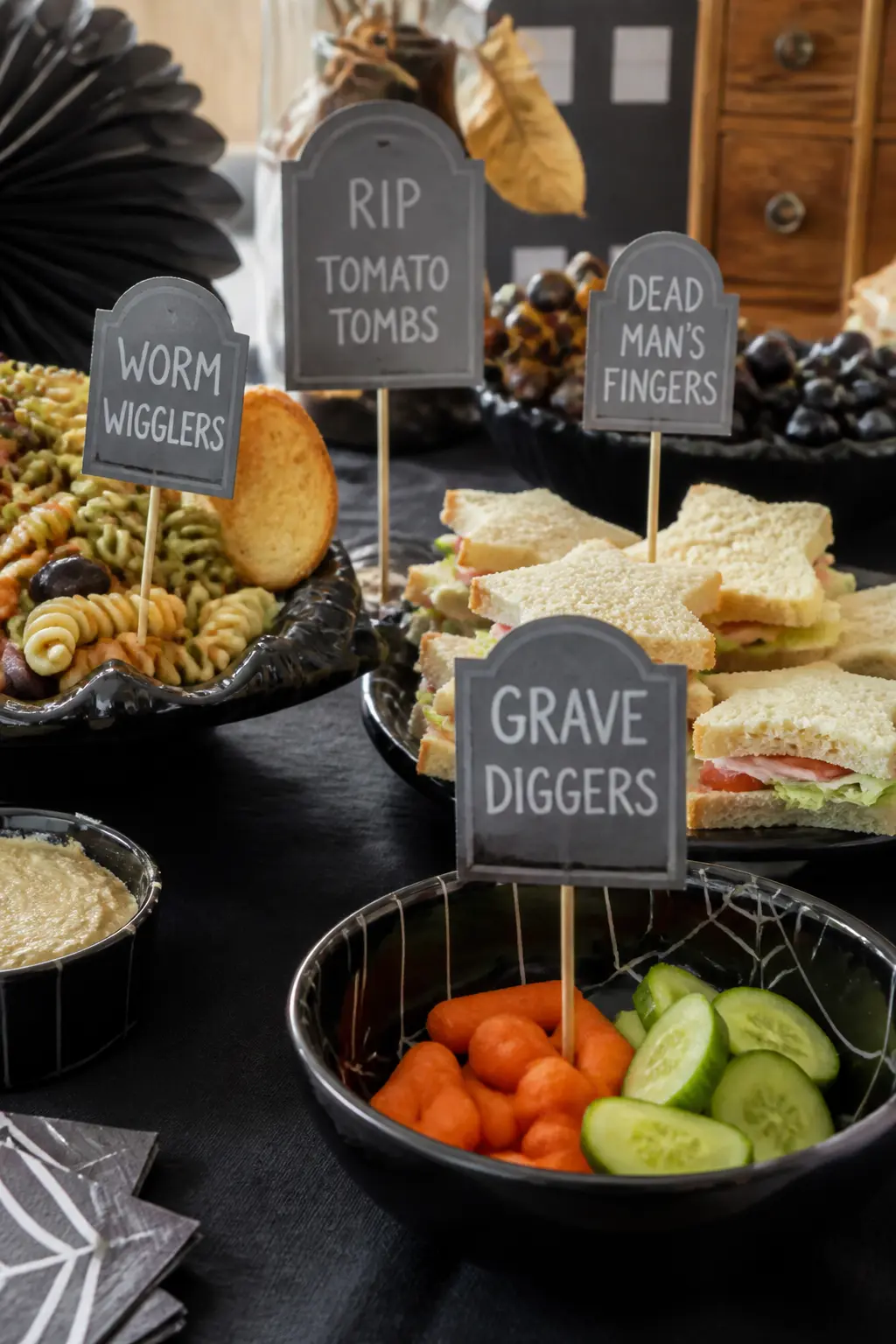 Cardboard Food Label Stakes — Cut tombstone or ghost shapes from card stock, paint them, and glue each one to a thin bamboo skewer. DIY cardboard Halloween