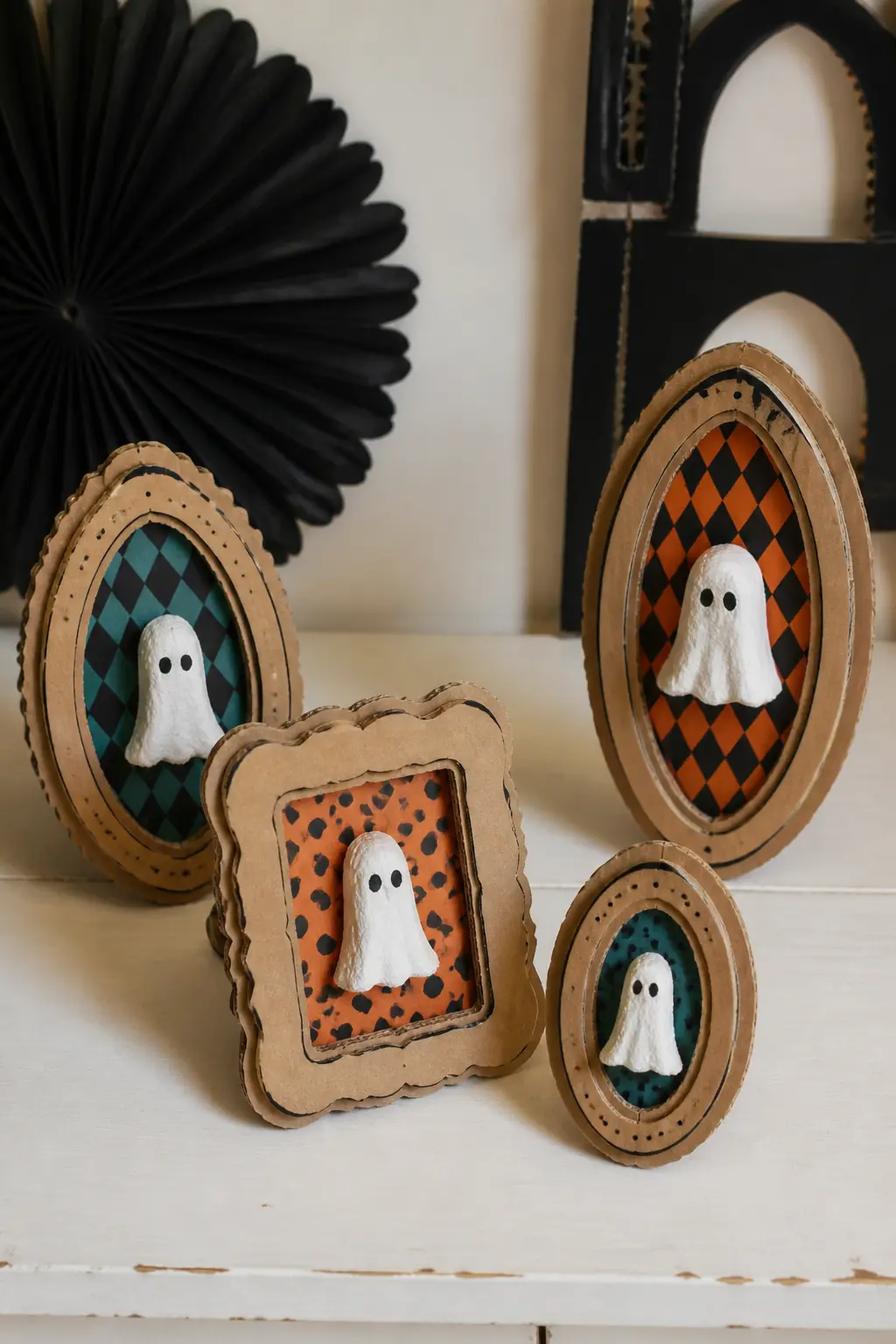 Egg-Carton Ghost Portrait Gallery — Cut wavy-edged frame shapes from corrugated cardboard and paint them in warm tan and mustard tones. DIY cardboard Halloween