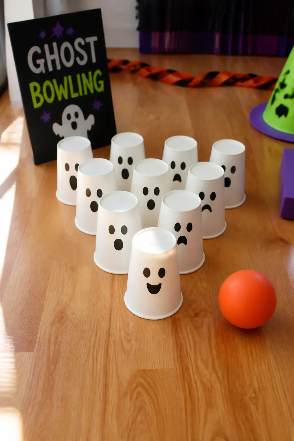 Ghost Bowling — Fill ten white paper cups with a little sand or uncooked rice to weight them, draw ghost faces on each cup with a black marker, and arrange