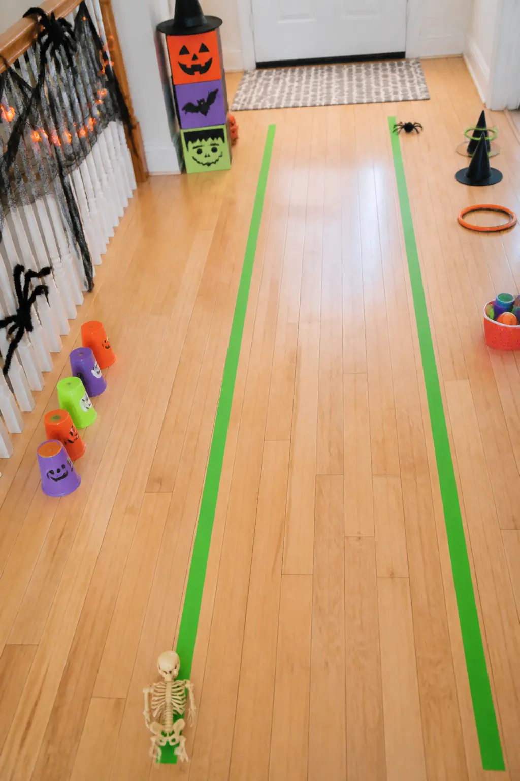 Mummy Tape Relay — Lay two parallel lanes on the floor with green painter's tape, each lane about forty centimetres wide and four metres long. Diy halloween