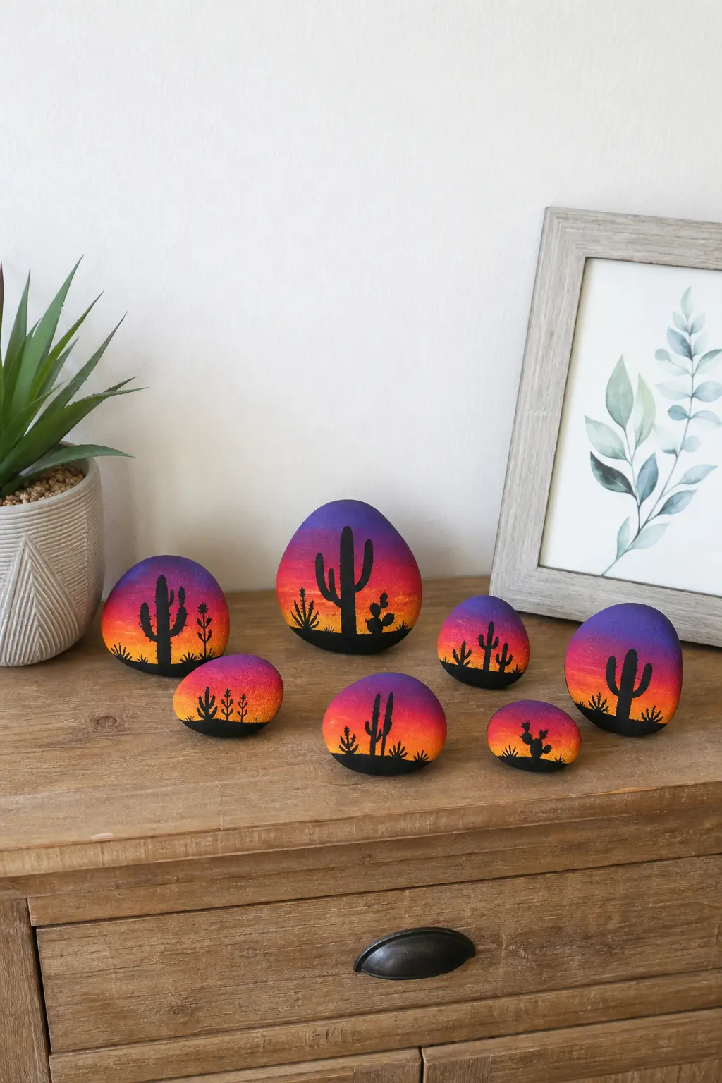 Desert Sunset Stones — Orange, pink and deep purple blended into a gradient sky, with one black cactus silhouette painted along the base, brings warmth to a