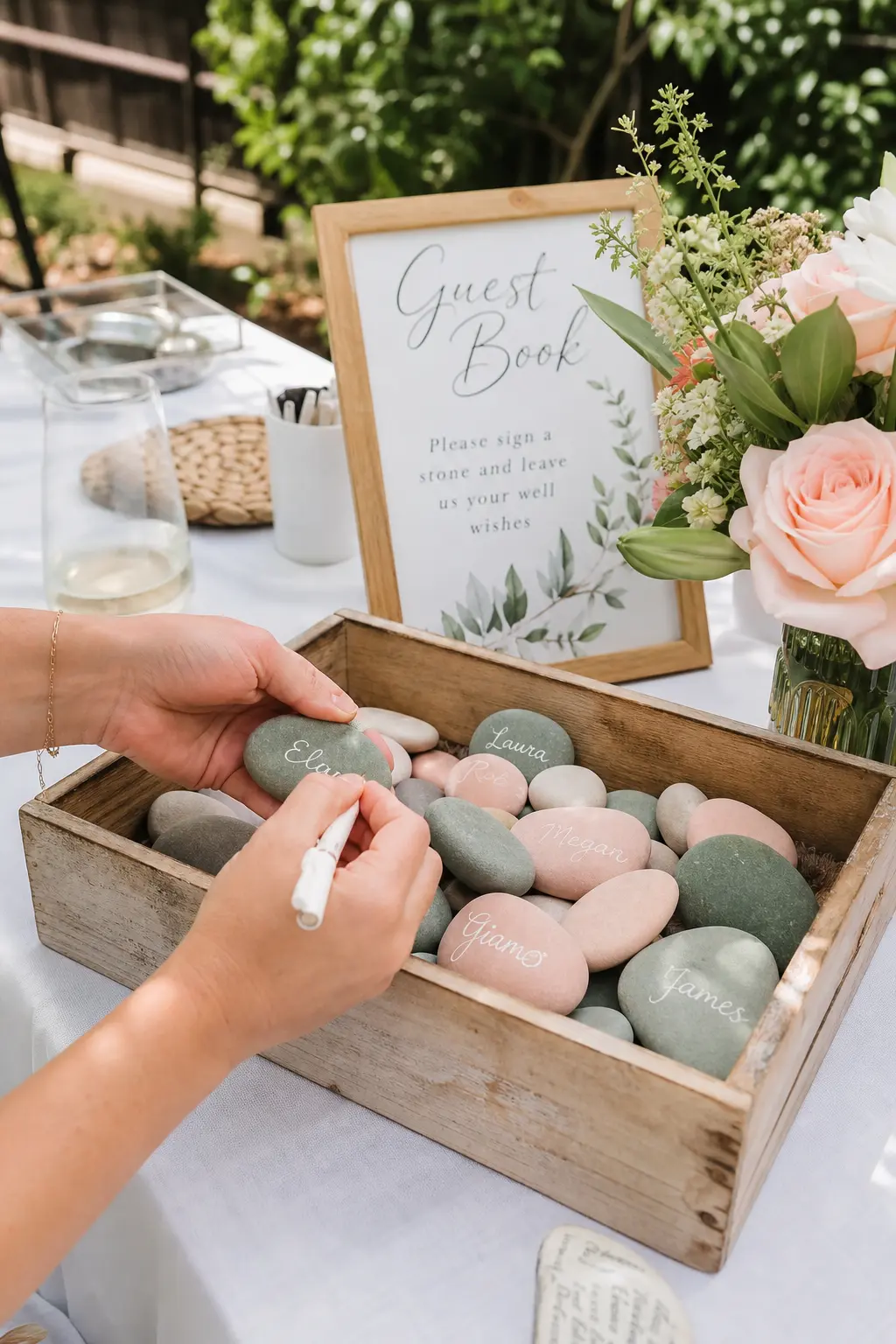 Wedding Guest Book Stones — Blush and sage stones, each guest signing one with a paint pen instead of a page, fill a wooden crate on the reception table and go