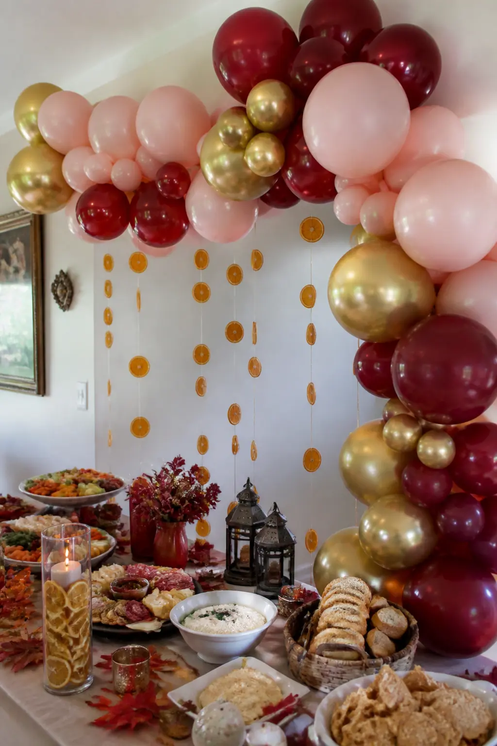 Burgundy, Blush and Gold Arch Framing a Food Table with Dried Orange Slices — Build a full arch in burgundy, blush and gold that frames a food or grazing table