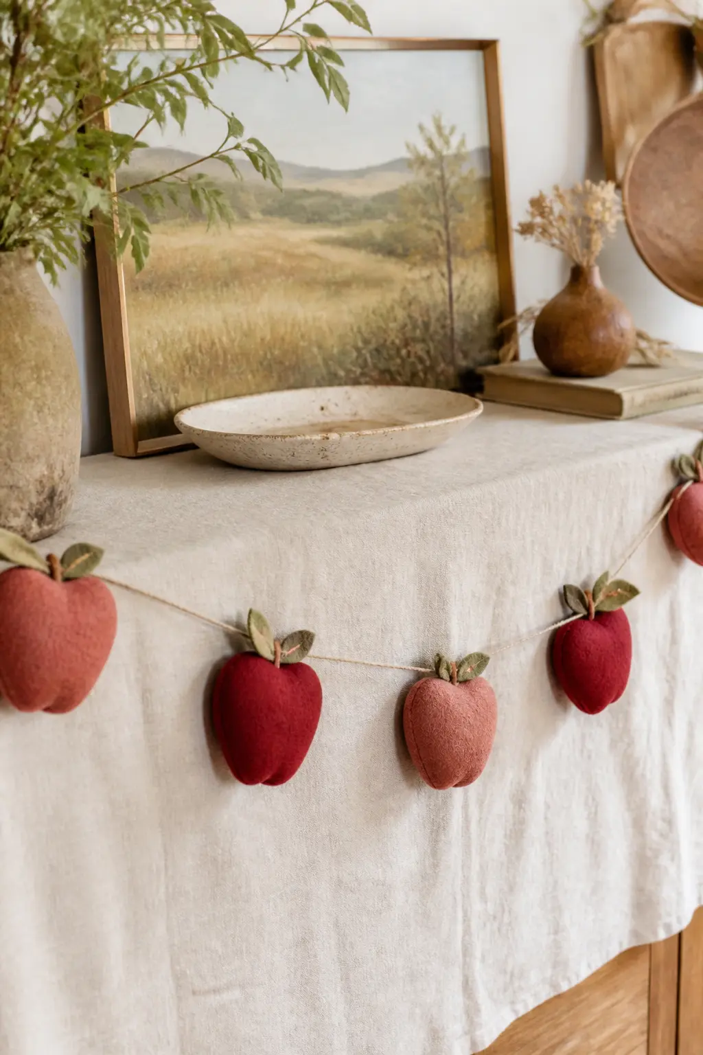 Apple Orchard Strand — Cut apple shapes from deep red and warm blush felt, each one slightly irregular as real apples are. Fall felt garland