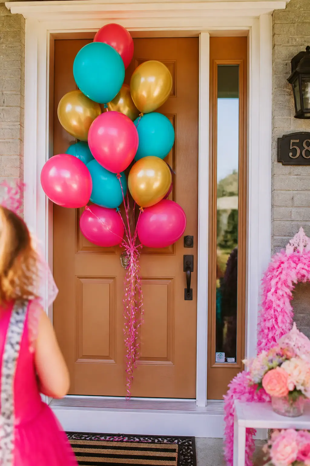 Balloon Cluster Door Entrance — Tie three or four balloons in hot pink, aqua and gold at different heights to a ribbon looped over the door knocker or