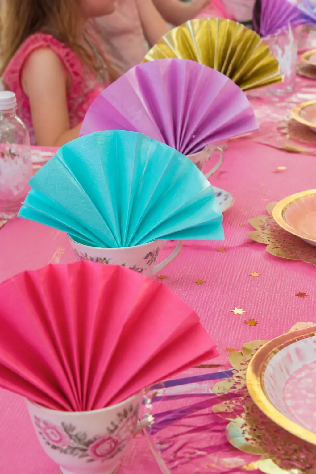 Colour-Blocked Paper Napkin Fans — Fold paper napkins into a fan pleat and stand one upright in each teacup so each place setting has its own small decorative