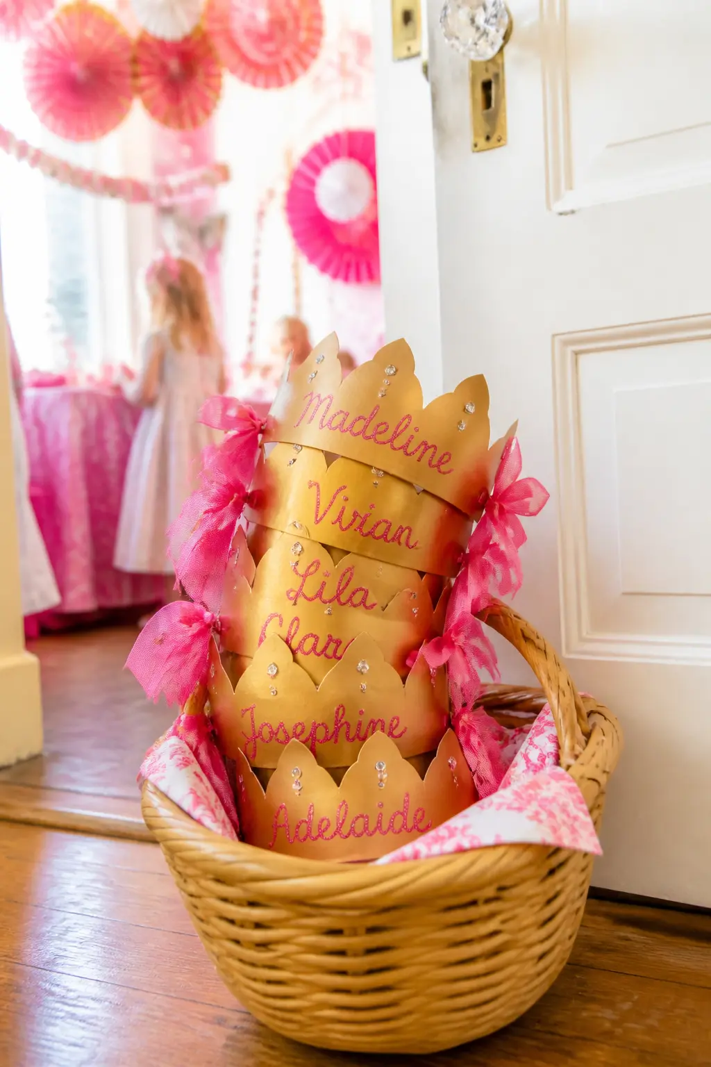 Gold Paper Crown Favour — A pre-assembled gold foil paper crown, personalised with each guest's name written in pink glitter pen and tucked into a glassine bag