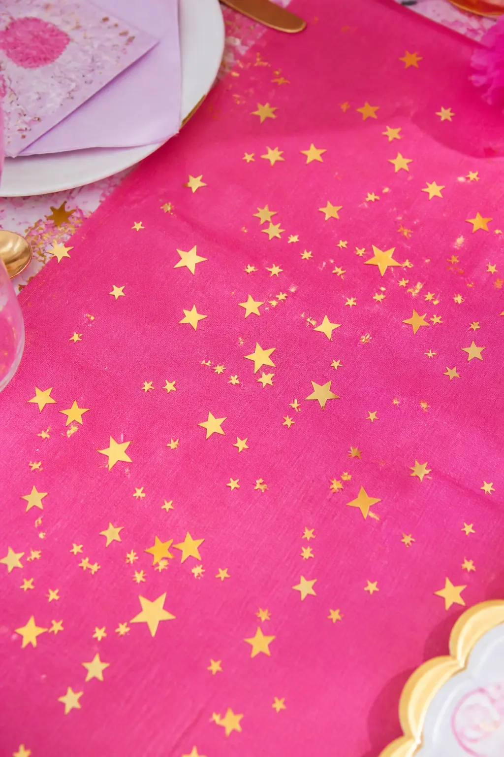 Gold Star Confetti Table Scatter — A generous scatter of gold foil star confetti across the table runner is the simplest detail on this list and one of the