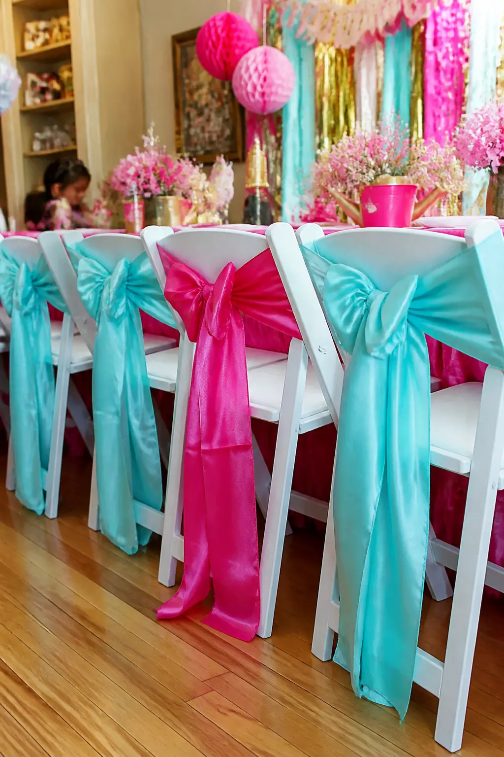 Pink Satin Chair Sash Bows — Tie a wide satin sash into a bow on the back of every chair at the party table: hot pink for the birthday girl's chair, aqua for