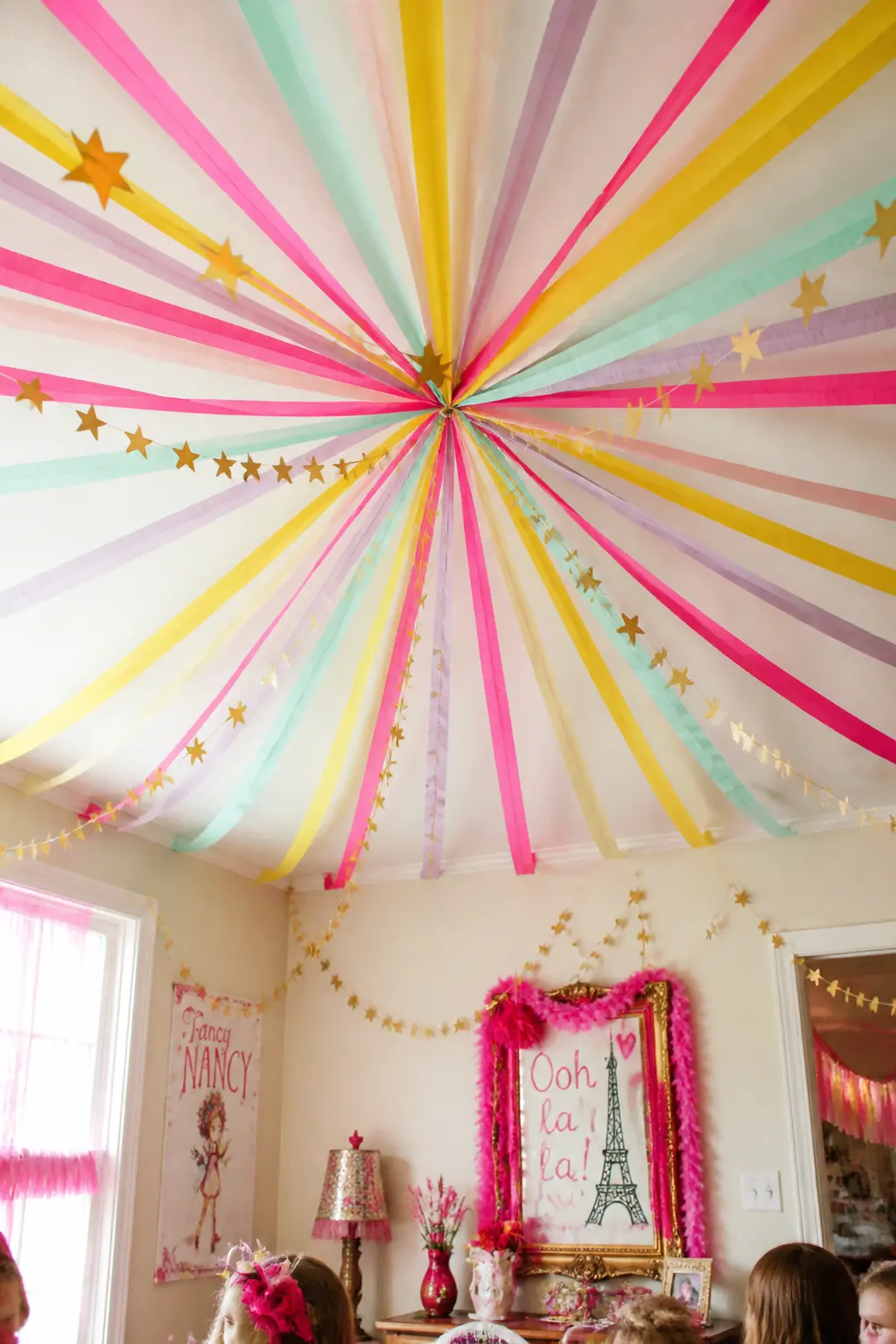 Streamer Sunburst from the Centre — Tape a single anchor point at the very centre of the ceiling and run crepe streamers outward to each wall like spokes of a