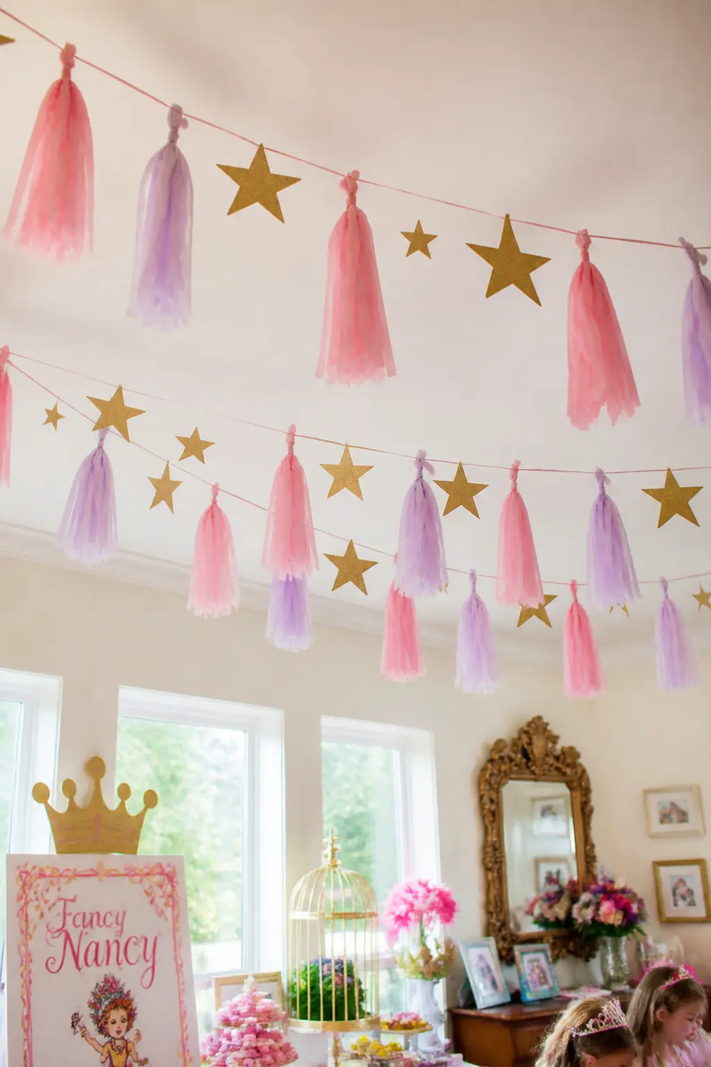 Tassel and Star Banner Overhead — Tissue paper tassels alternated with glitter star cutouts on a length of twine make a banner that reads as both festive and
