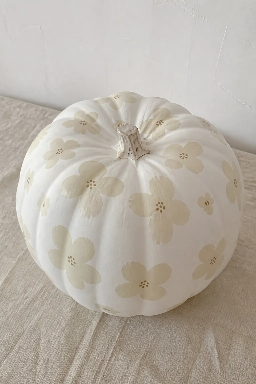 Cream Flowers on a White Pumpkin — Tonal palettes are the quietest and most sophisticated option in this list. Floral painted pumpkin