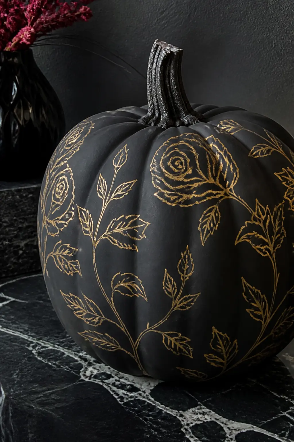 Gold Outlines on a Matte Black Pumpkin — A matte black base with gold floral outlines is the most dramatic palette in this list and requires the least actual