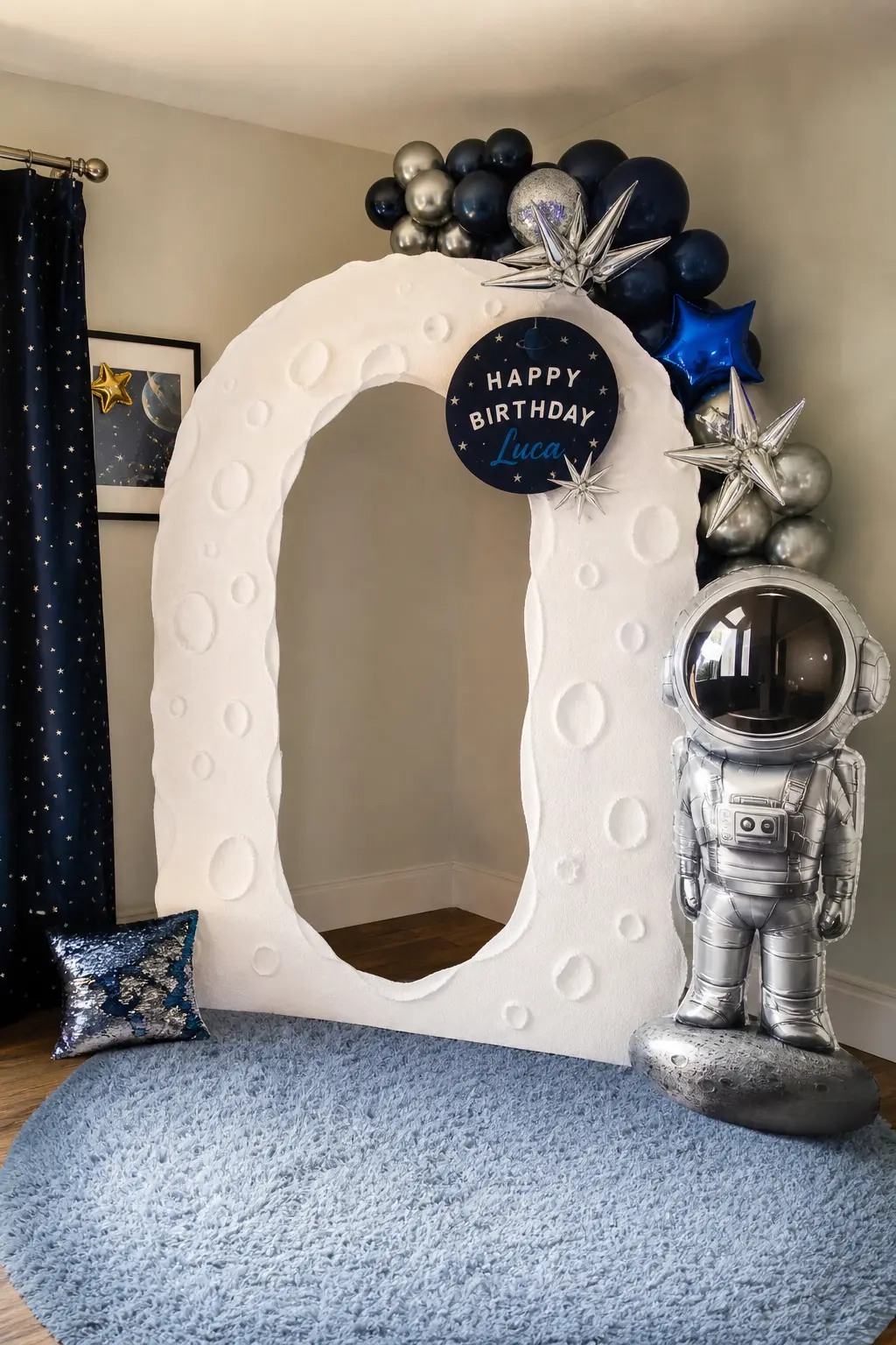 Astronaut Cutout Standee Corner — A white foam arch, cut to resemble a moon crater edge, frames a freestanding silver astronaut cutout in the corner of a room.