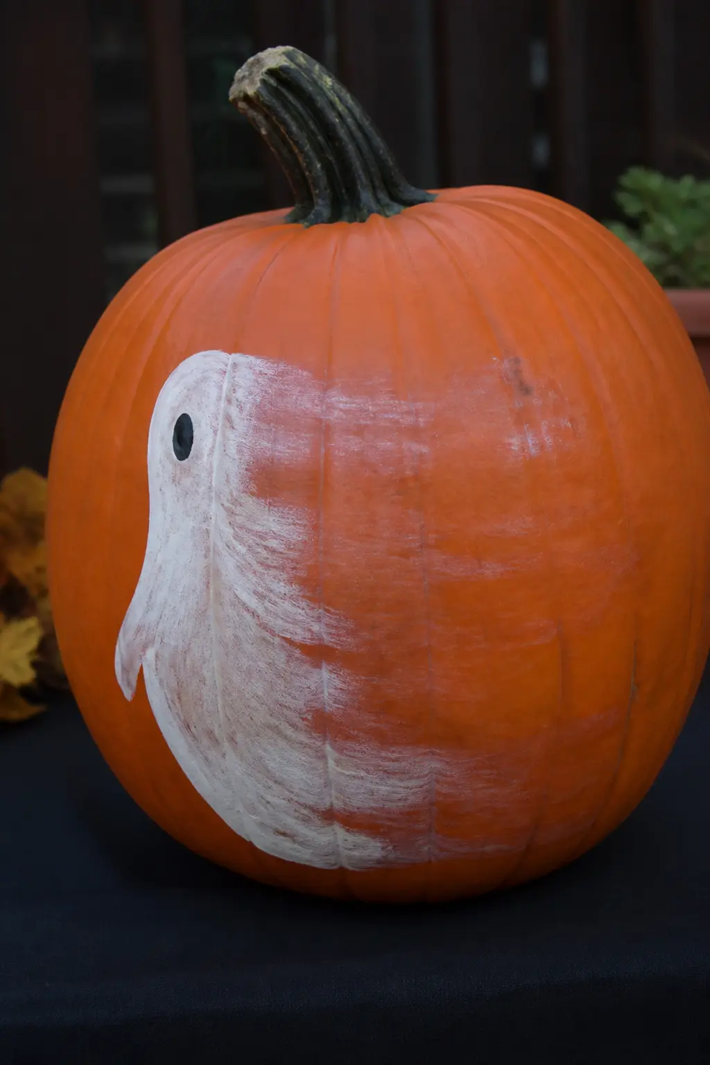 Ghost Half Faded Into the Pumpkin — The ghost is fully rendered on one side of its body and fades progressively to nothing on the other, as if it is in the