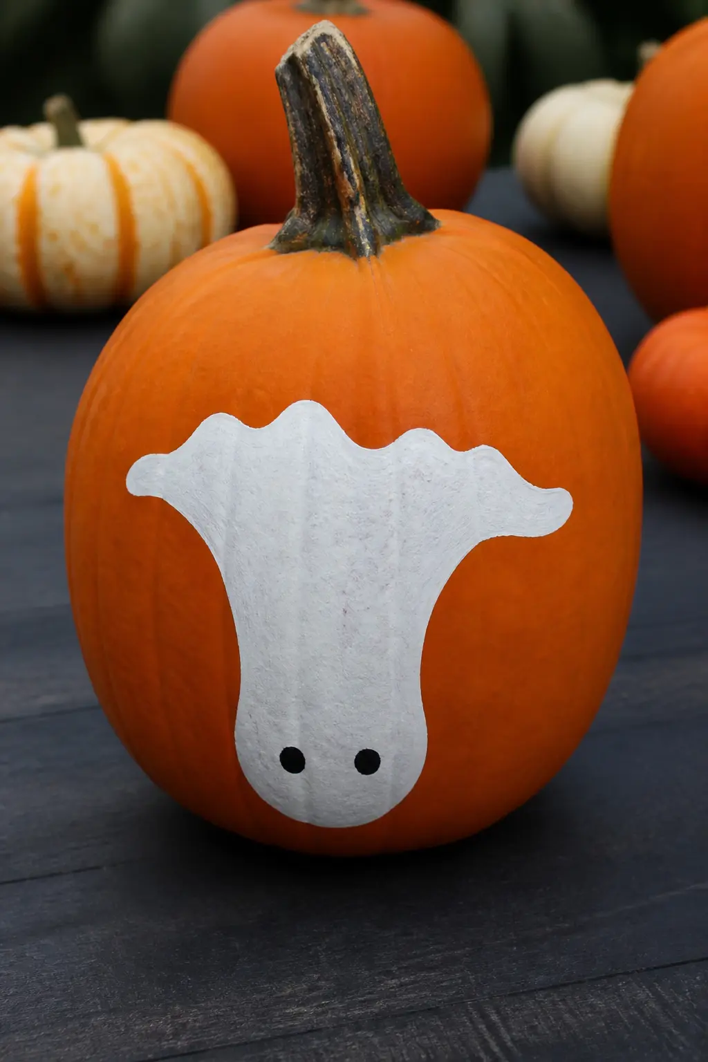Ghost Painted Upside Down — The ghost is oriented with its head at the bottom of the pumpkin and its hemline at the top. Ghost painted pumpkin