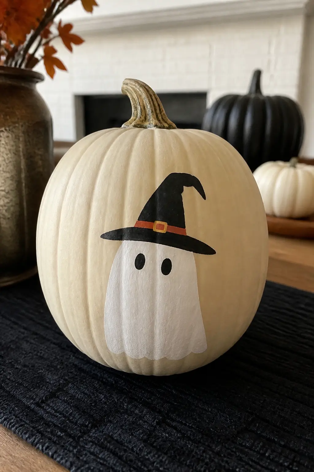 Ghost Wearing a Witch Hat — A black pointed hat, painted at a slight tilt, sits on top of the ghost's head. Ghost painted pumpkin