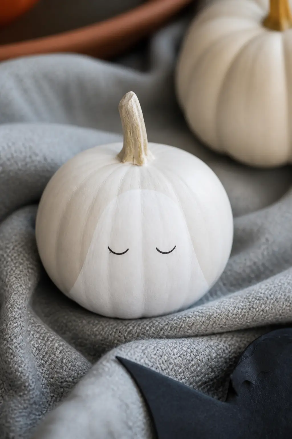 Sleeping Ghost With Closed Curved Eyes — The eyes curve downward as two small arcs, like closed crescent moons. Ghost painted pumpkin