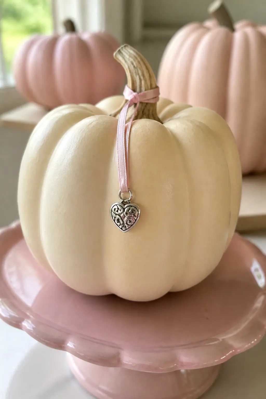 Cream Pumpkin With a Charm Hung From the Stem on a Pink Ribbon — Paint the pumpkin in cream. Girly painted pumpkin