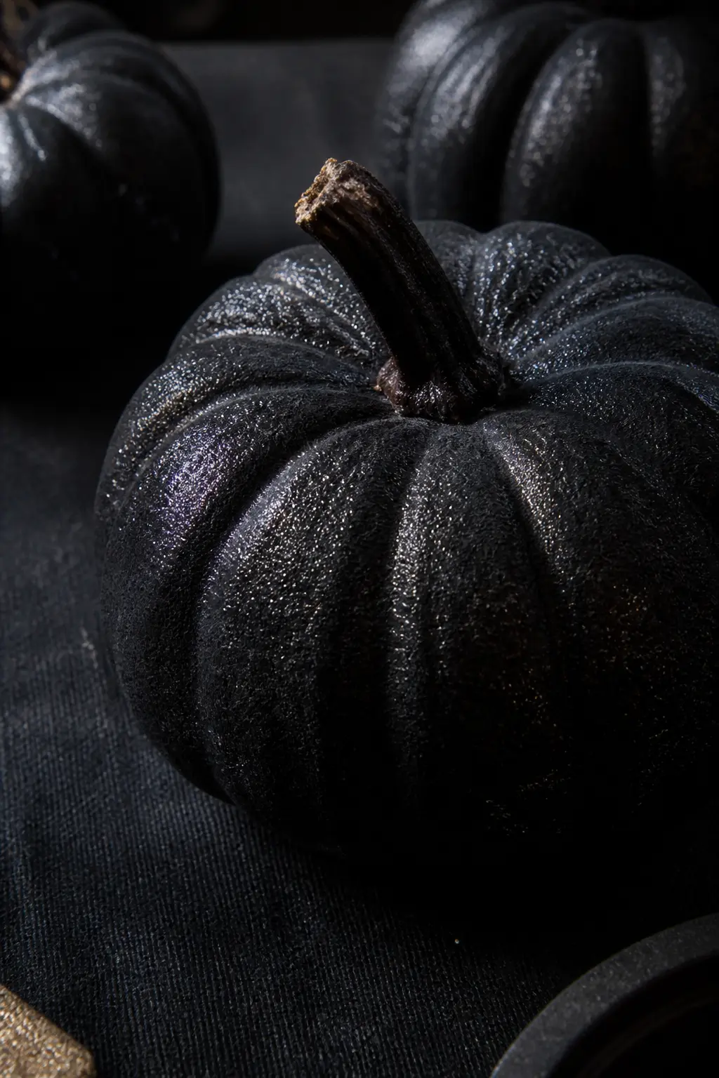 Black Pumpkin With Glitter Mixed Into the Paint — Mix fine black or charcoal glitter directly into matte black paint until the mixture is roughly one part