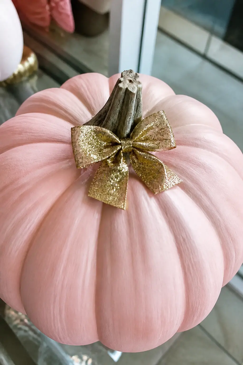 Blush Pumpkin With a Single Gold Glitter Bow at the Stem — Paint the pumpkin blush pink, two even coats. Glitter pumpkin