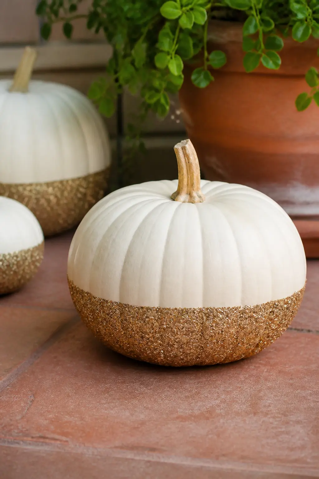 Cream Pumpkin Dipped in Gold Glitter on the Bottom Half — Paint the whole pumpkin cream. Glitter pumpkin