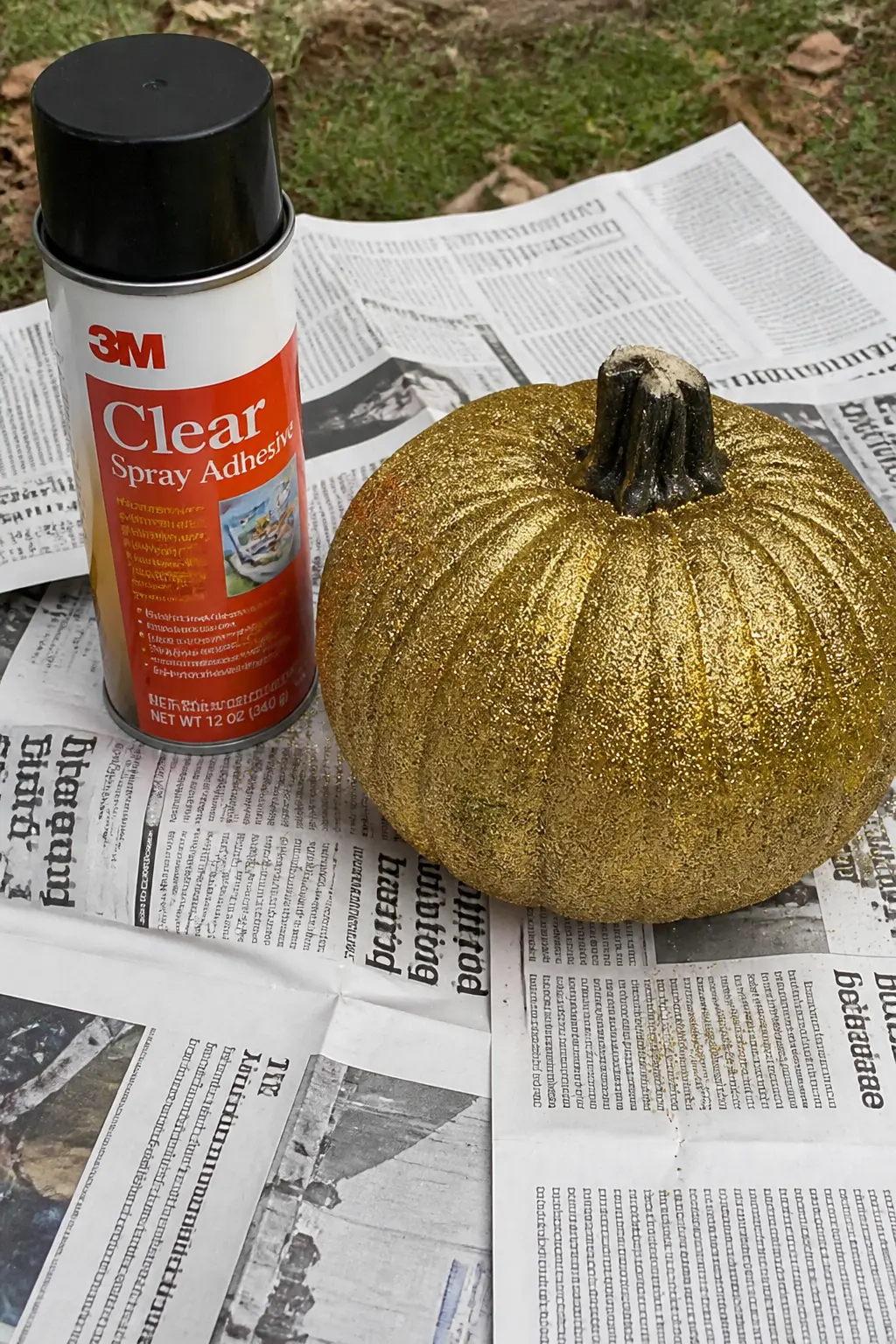 Method: Spray Adhesive for an Even Surface Rather Than Brushed Glue — Hold a can of craft spray adhesive thirty centimetres from the painted pumpkin and spray