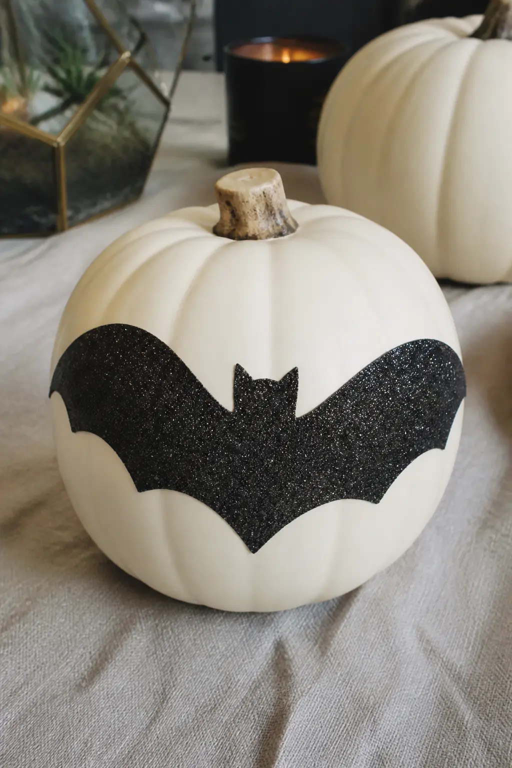 White Pumpkin With Adhesive Vinyl Bat Shape Glittered Inside the Lines — Paint the pumpkin white. Glitter pumpkin