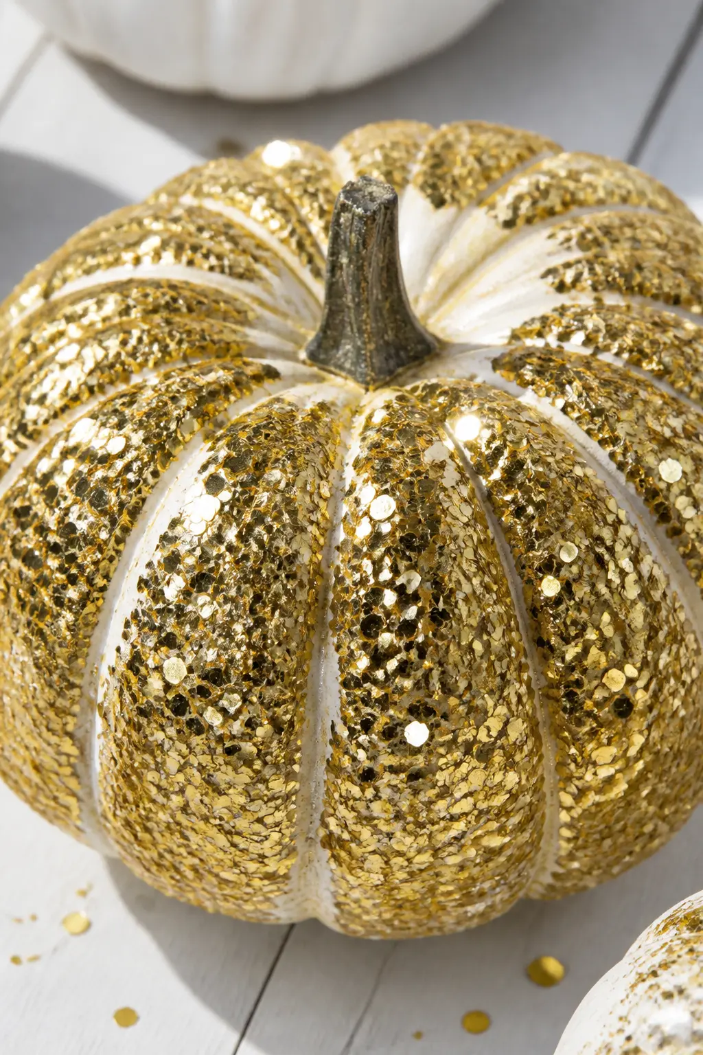 White Pumpkin With Chunky Gold Glitter Pressed On — Paint the pumpkin white. Glitter pumpkin
