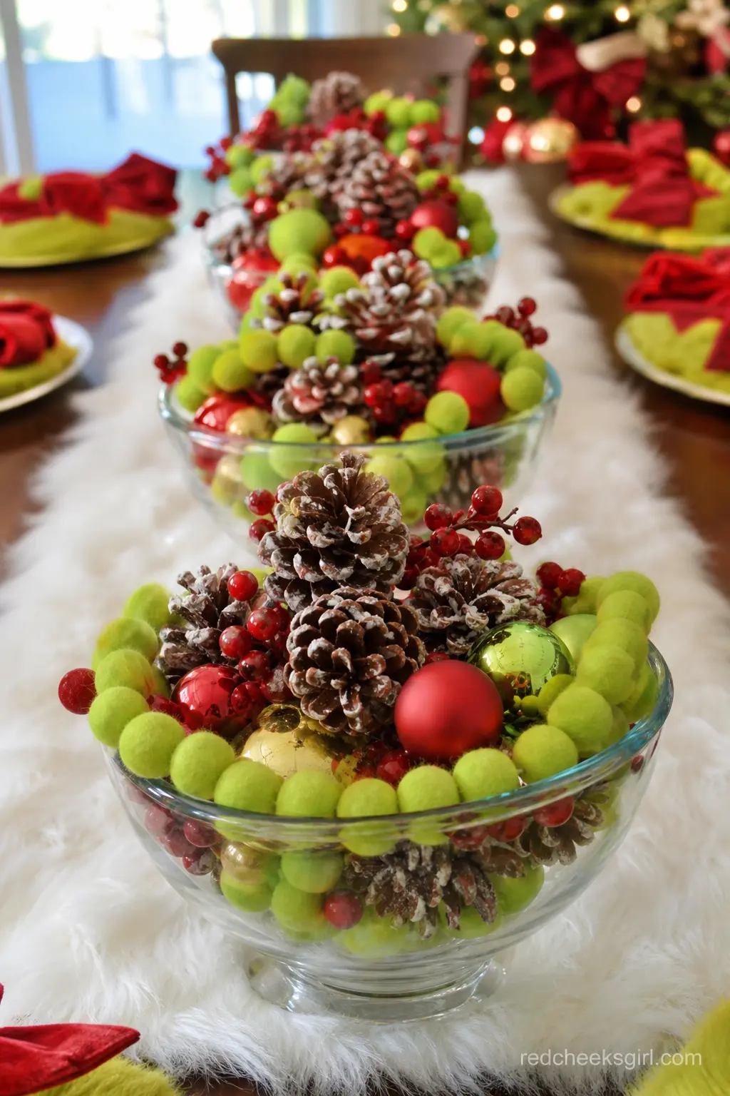 Pine And Pom-Pom Runner Bowls — Three low glass bowls, spaced down the center of the main table, filled with sugared pinecones, dried red berries and chunky