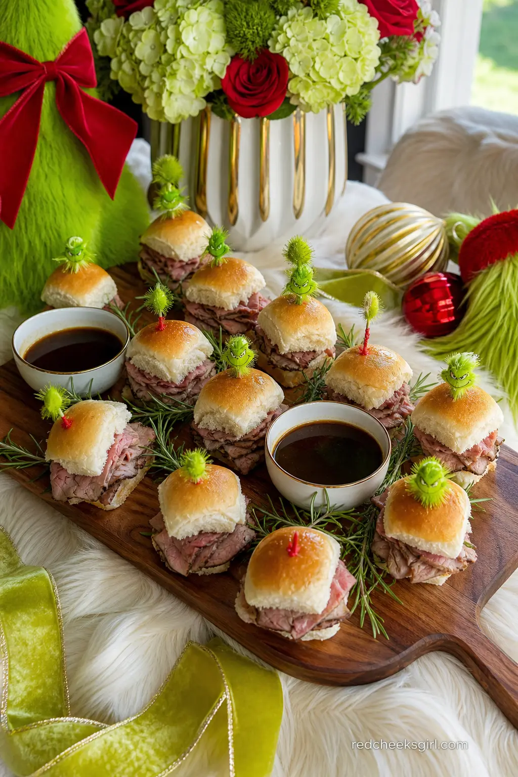 Roast Beast Slider Board — A large wood board of small roast beef sliders on soft rolls, arranged in tight rows with sprigs of rosemary and small bowls of