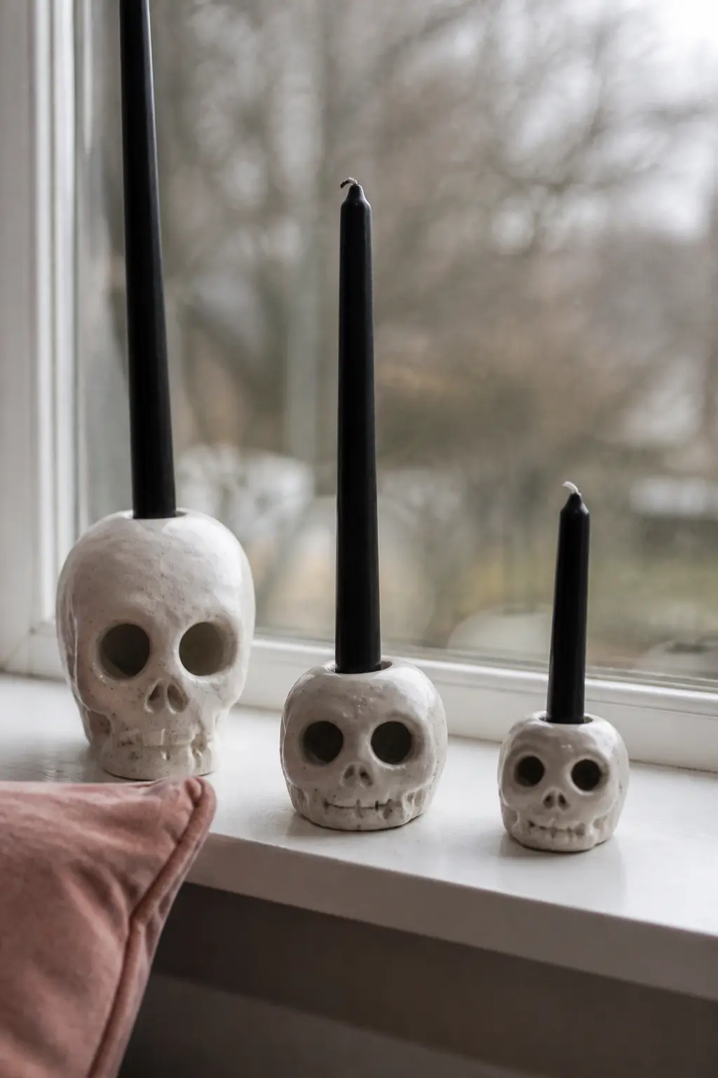Air-Dry Clay Skull Taper Candle Holder — Roll a fist-sized ball of air-dry clay, press a finger-sized hole through the top to hold a taper candle, then use a