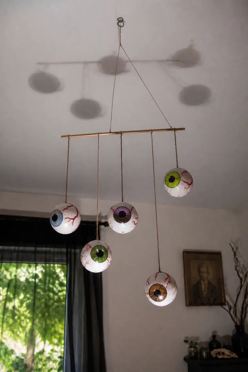 Fishbowl Eyeball Mobile — Cut a wooden dowel to about 40 cm and hang four or five painted styrofoam eyeballs from it at different lengths using invisible