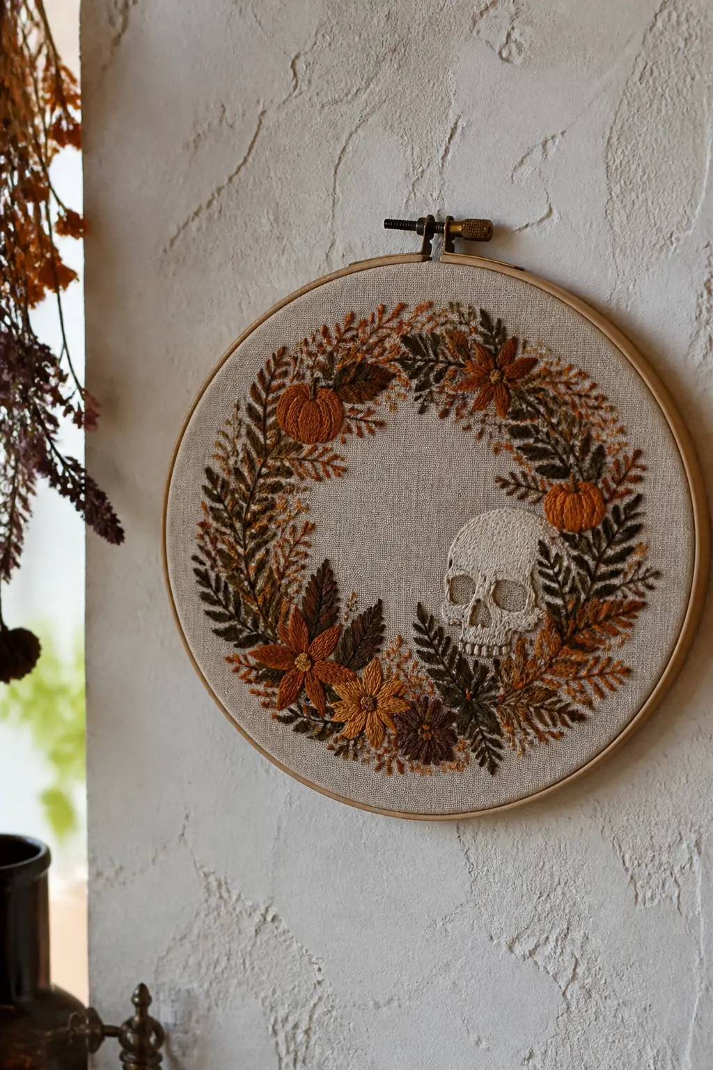 Autumn Wreath with Hidden Skull — A full circular wreath of embroidered botanicals: rosehips, dried seed heads, small oak leaves, fern fronds, all in burnt