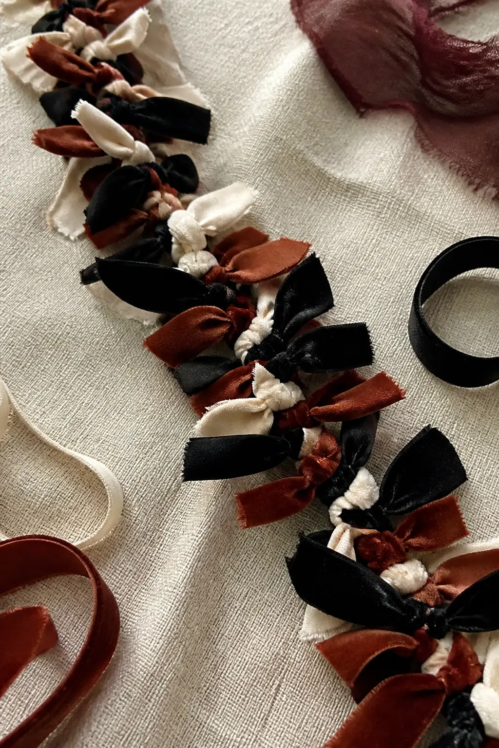 Knotted Velvet Ribbon Garland — Cut lengths of velvet ribbon in black, deep rust and ivory, each about thirty centimetres long. Halloween fabric crafts