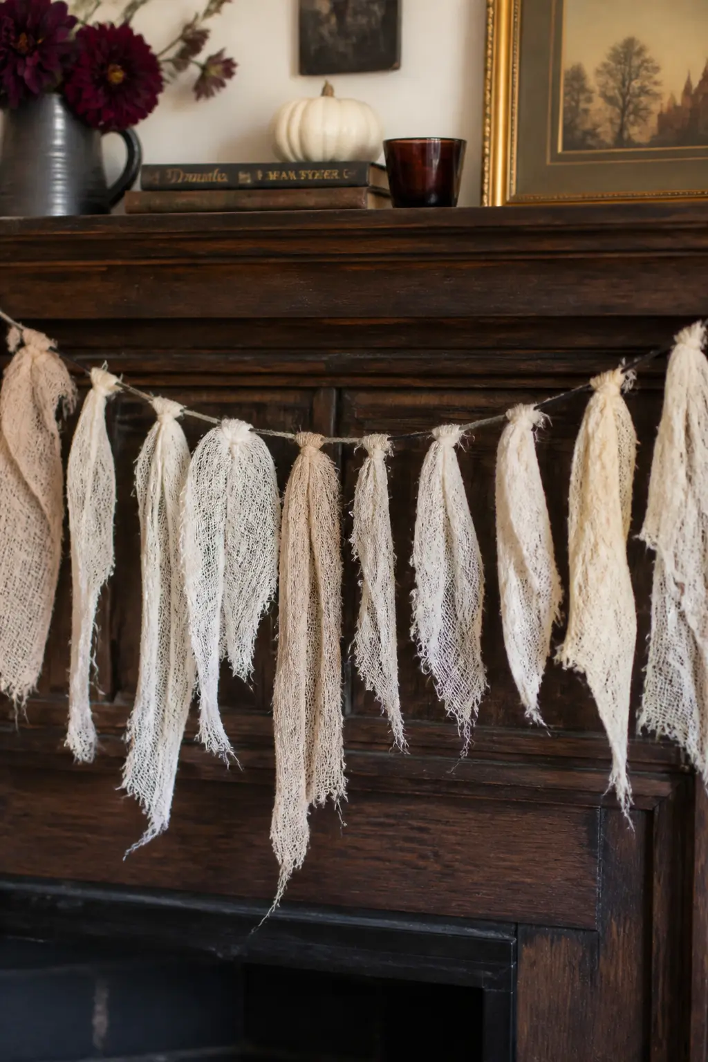 Torn Cheesecloth Garland — Tear cheesecloth into long strips about eight centimetres wide, then tie them in loose double knots along a length of black jute