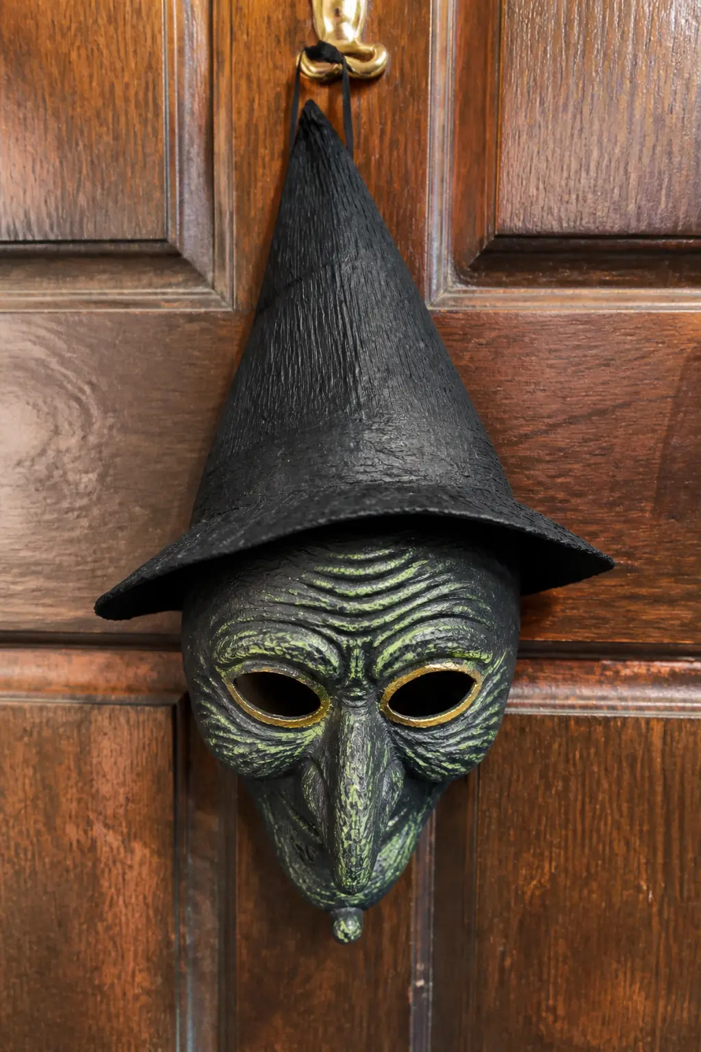 Crepe Paper Witch Mask — Glue stretched black crepe paper over a papier-mache half-mask base while the surface is still slightly damp with diluted PVA.