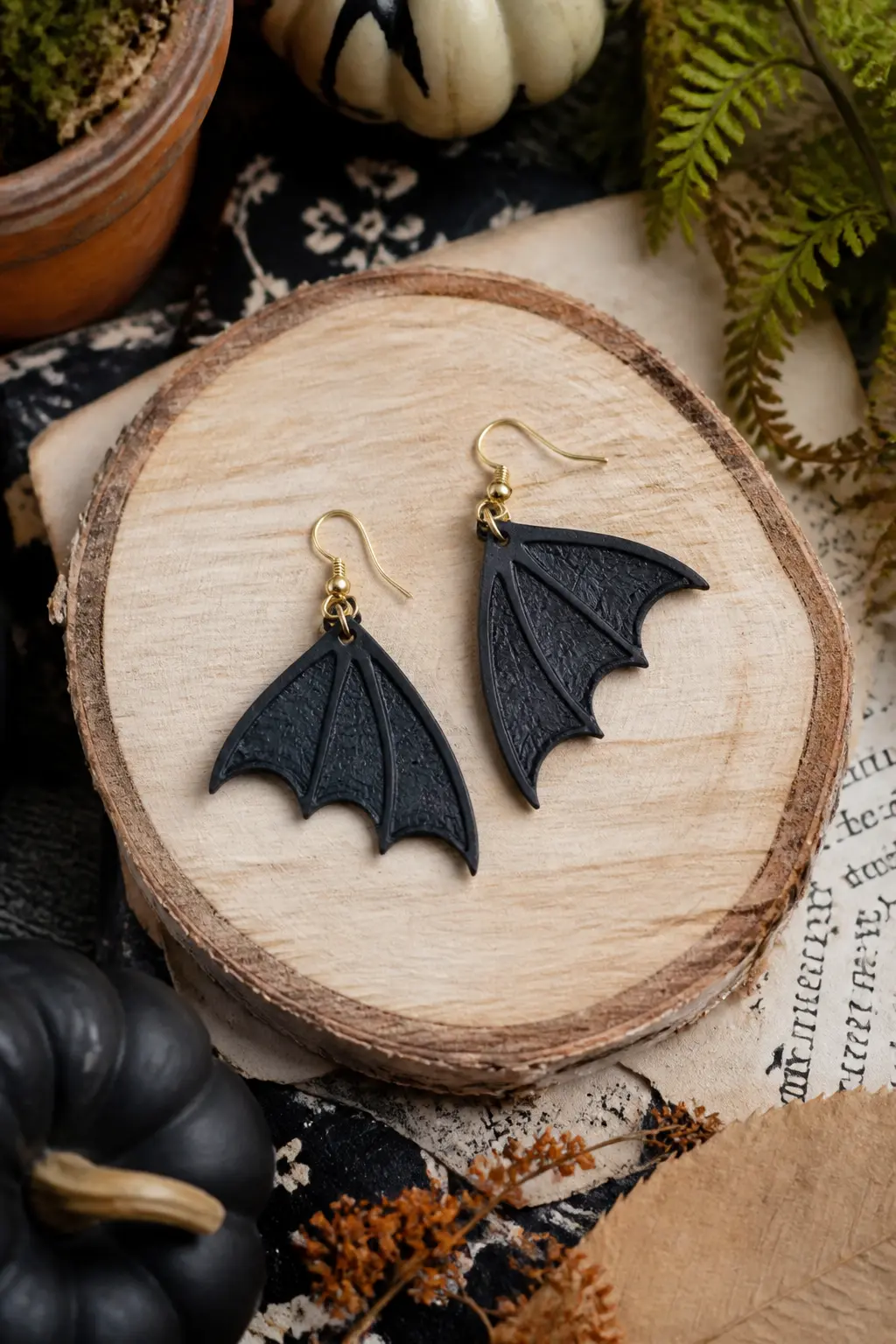 Botanical Bat Wing Earrings — Cut two bat wings from a sheet of black clay using a template you draw on paper and cut out yourself: roughly a wide M shape with