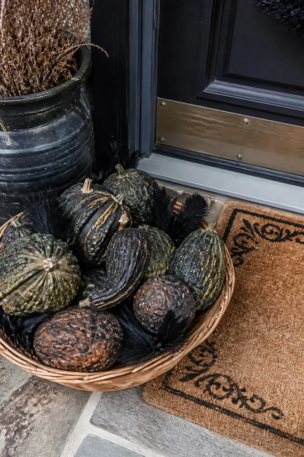 Wicker Basket of Dark Gourds by the Mat