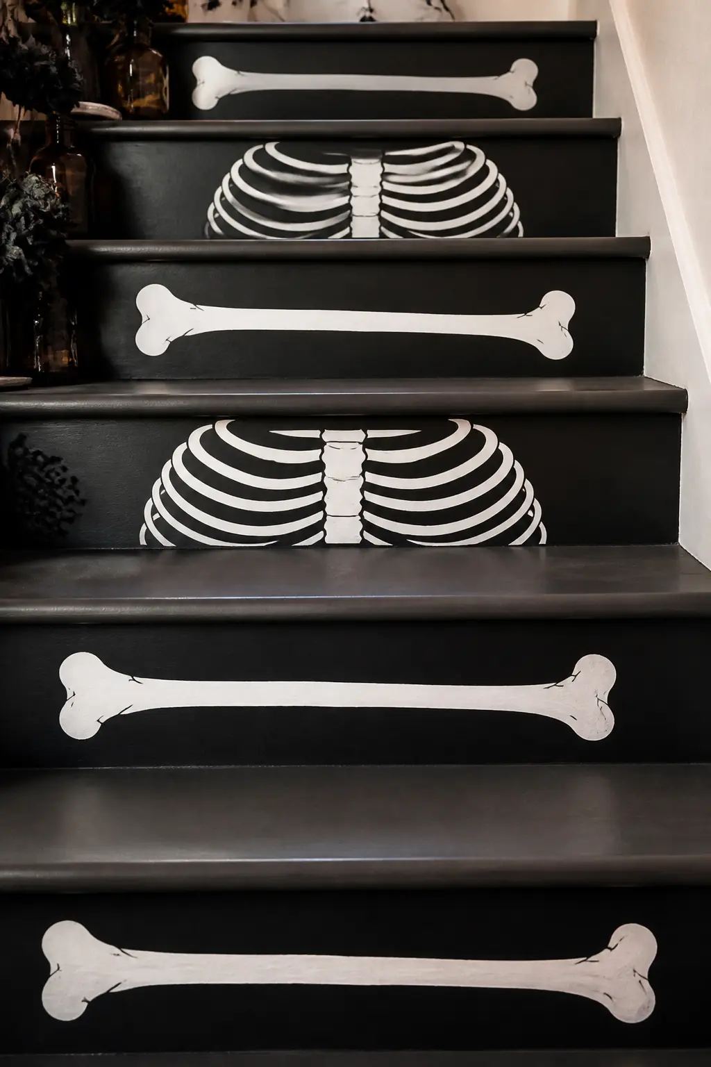 White Bone Motif on Black Riser — Paint the risers black and stencil a single bone or rib motif in white on each one, centred horizontally. Halloween staircase