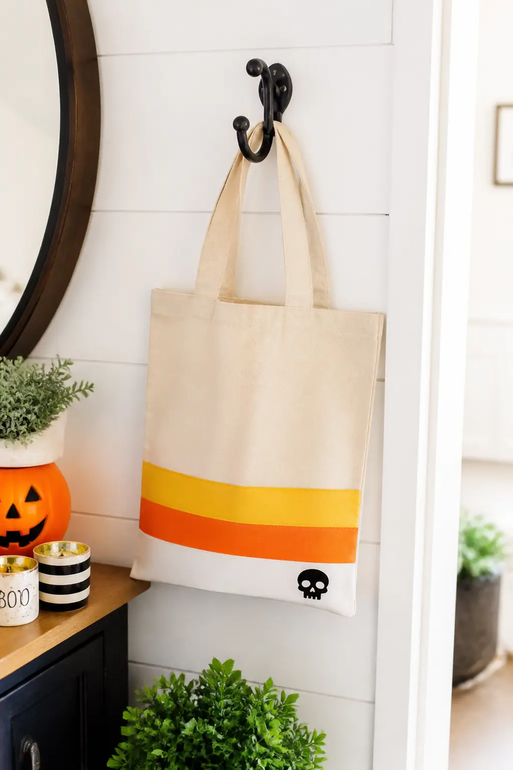 Candy Corn Stripe at the Base — Cut three horizontal band shapes in yellow, orange and white HTV to run across the bottom third of the bag, mimicking a candy