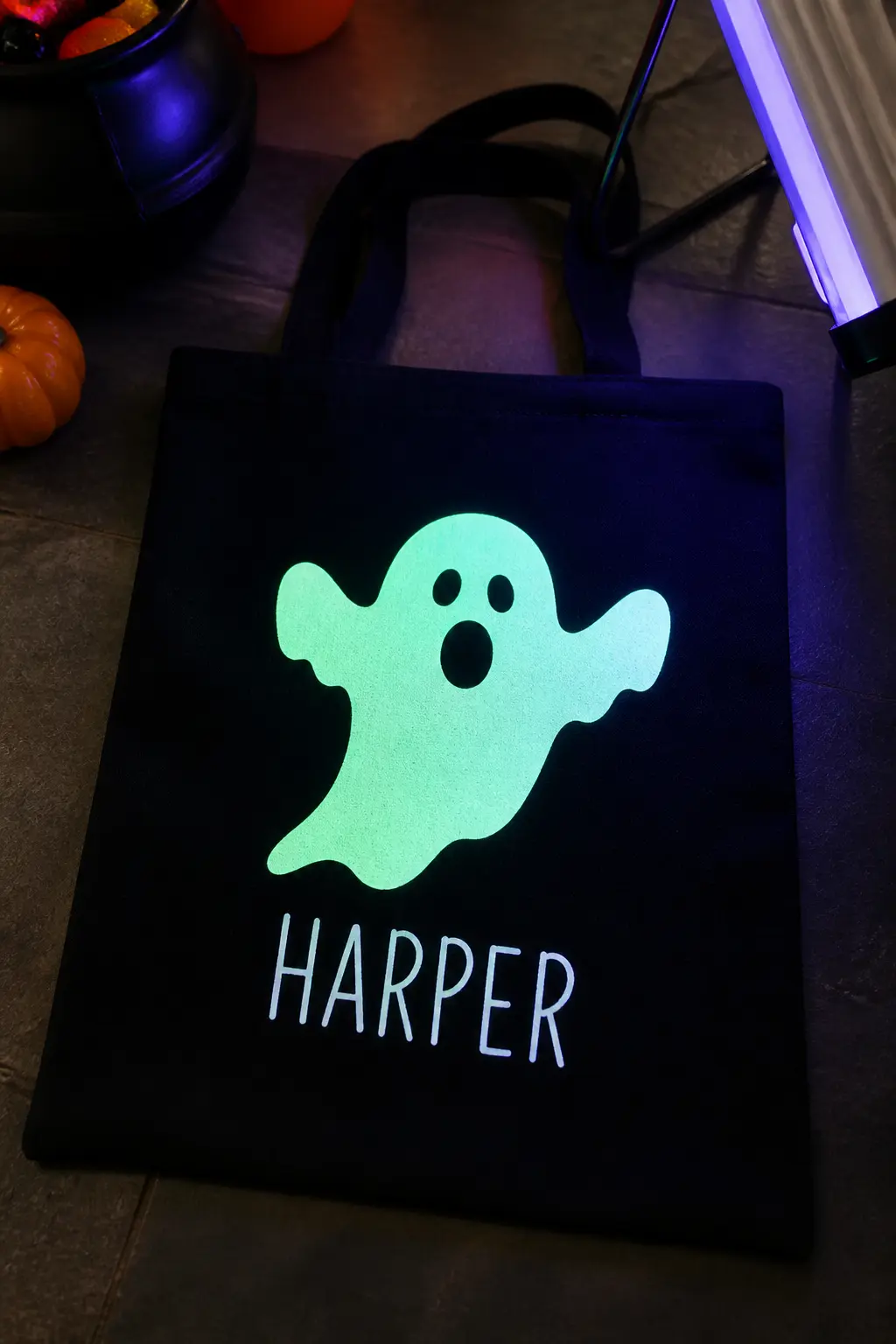 Glow-in-the-Dark Ghost on Black Canvas — Cut a classic rounded ghost shape from glow-in-the-dark heat transfer vinyl and press it to a black canvas tote.